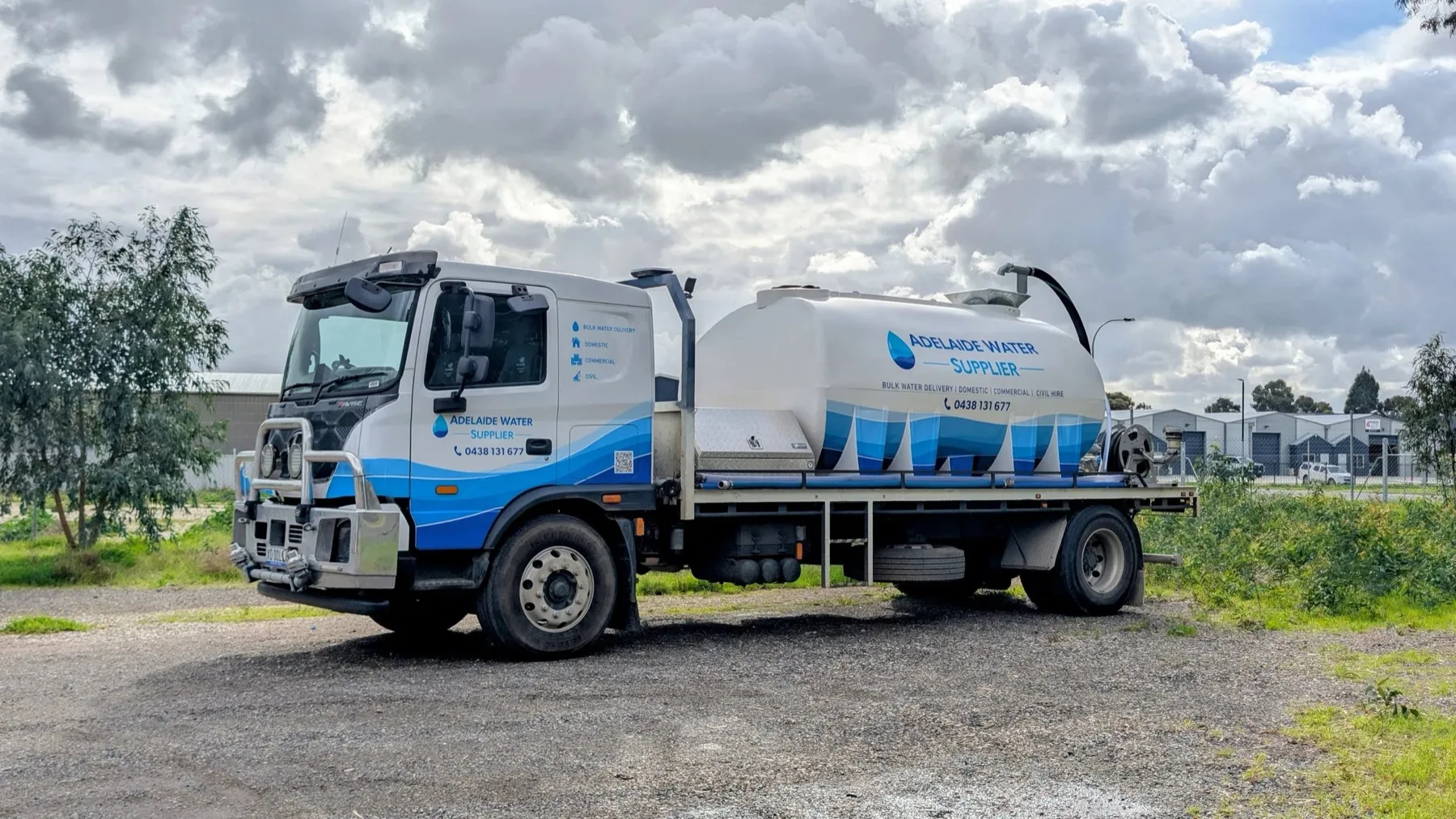 An Adelaide Water Supplier truck in its blue and white livery, with the business name and 0438 131 677 on the door and the tank